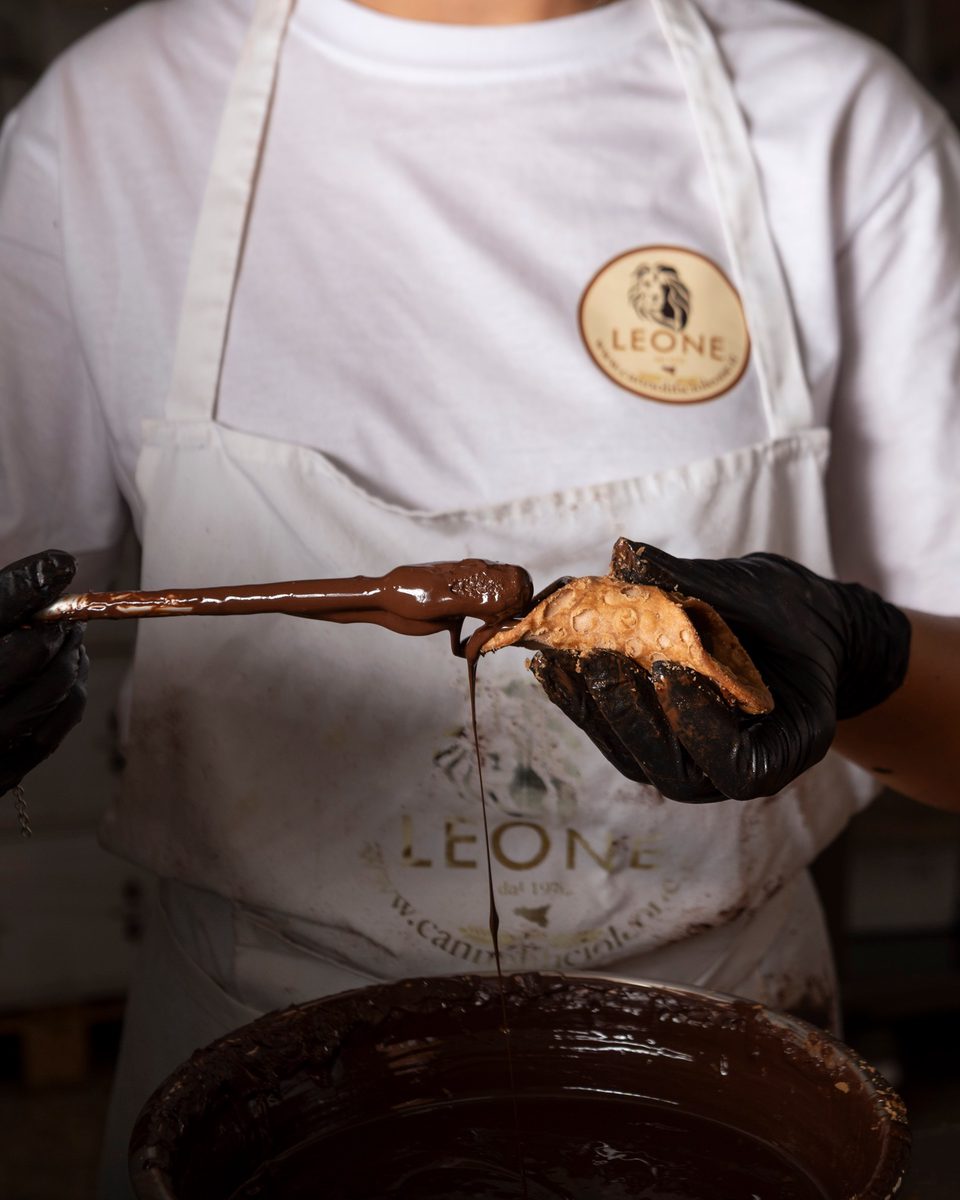 Applicazione manuale del cioccolato all'interno di una scorza di cannolo