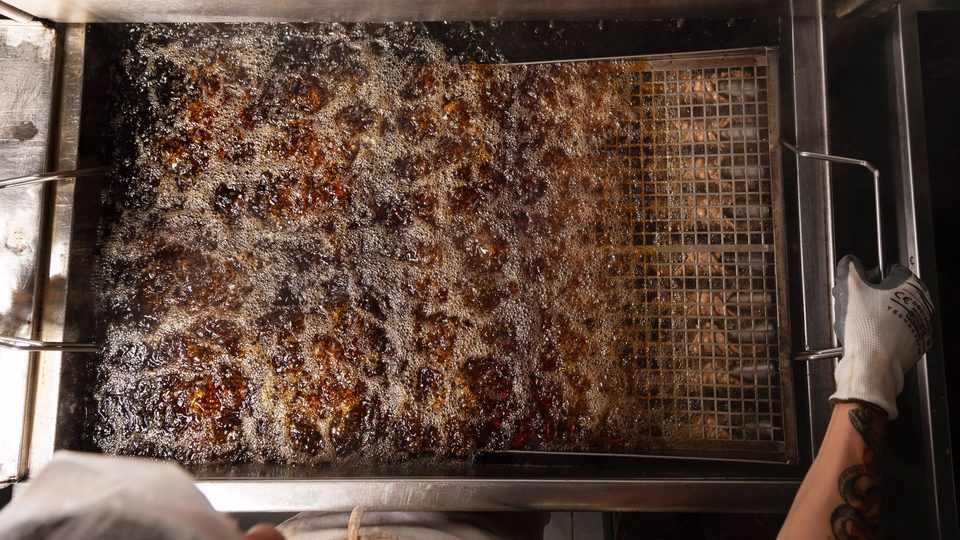 Scorze di cannolo immerse nell'olio durante la frittura