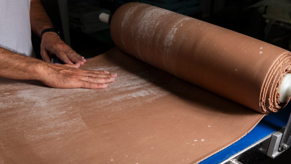 Ampia sfoglia per cannoli stesa sul piano di lavorazione