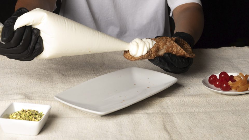 Farcitura di un cannolo Leone con ricotta da una sac à poche